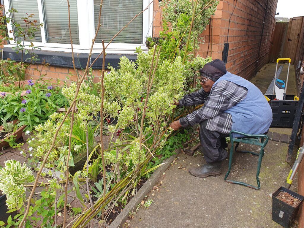 Eunice weaving a hurdle in her front garden 2024