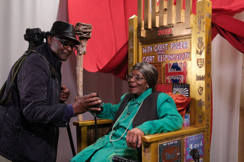 Eunice checking Vanley Burke's photo of her on 'The Throne' - a project exploring leadership with young people